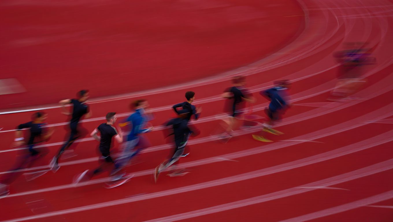 Coureurs adultes flous sur piste pendant un test de Cooper sans texte ni marque visible